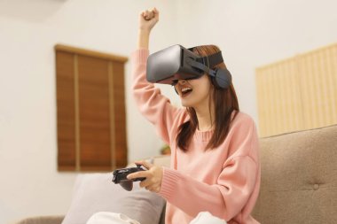 Ev konseptinde yaşam tarzı, LGBT lezbiyen kadınlar joystick ile oyun oynuyor ve kazanan jest yapıyor.