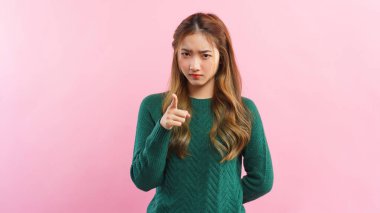 Memnuniyetsizlikle işaret eden genç kadın ve pembe arka planda izole edilmiş kızgın yüz..