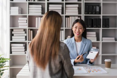 Businesswoman showing numbers of business profit to partner and discuss about new project together.