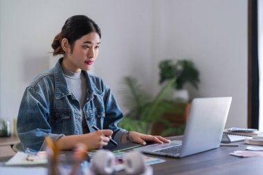 Grafik tasarımcı kadınlar grafik tasarımı hakkında tasarım yapmak için dizüstü bilgisayar ve dijital tabletle çalışıyorlar.