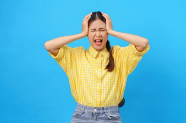 Kadınlar kendilerini stresli hissederken başlarını tutuyorlar ve açık mavi arka planda izole edilmiş baş ağrısı.