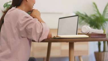 Dizüstü bilgisayarda veri okumaya çalışan ve yeni başlatılan proje hakkında düşünceli bir girişimci..