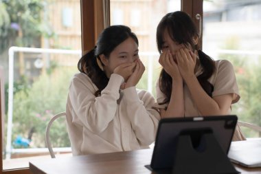 İki iş kadını korku filmi eğlencesini izlemek için tablet kullanıyor. Yeni iş projeleri ve iş yerinde iş arkadaşlığı sohbetleri başarıyla sonuçlanıyor..