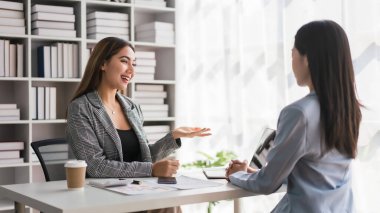 İş kadını, iş ve finans belgesini ortaklara açıklamak üzere dizüstü bilgisayarda çalışıyor.