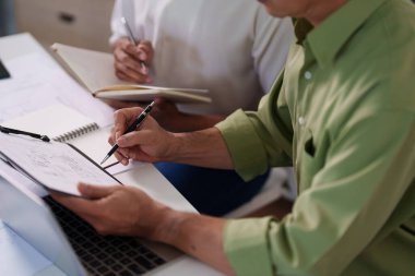 Bir inşaat projesi için maliyet tahmini ve kaynak tahsisi üzerinde çalışan profesyonel bir mühendislik ekibi.