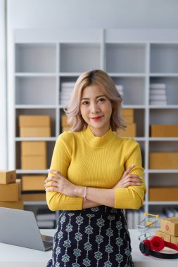 Çevrimiçi satıcı güvenli bir şekilde ana ofiste paketlenmiş paketler ve dizüstü bilgisayarla teslimata hazır bekliyor.