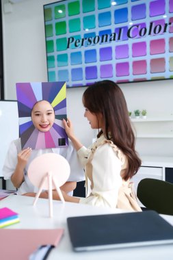 Genç Asyalı kadınlar en iyi makyaj renklerini ve moda tarzlarını belirlemek için kişisel renk analizi yaptırıyorlar. Stüdyoda giysi ve güzellik seçimleri için profesyonel renk danışmanlığı.