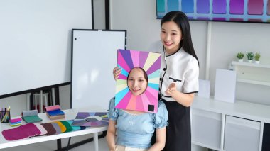 Genç Asyalı kadınlar mevsimlik renk paletiyle kişisel renk analizi yaptırıyorlar. Giysi ve makyaj için en iyi renklerini bul. Gardırop ve güzellik için profesyonel danışmanlık.