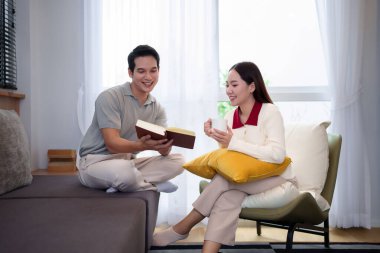 Genç bir Asyalı çift evde samimi bir anı paylaşıyor. Asyalı kadın kahvesini yudumlarken Asyalı adam kitap okuyor. İkisi de gülümsüyor, mutluluk saçıyor ve rahat bir oturma odasında vakit geçiriyorlar..