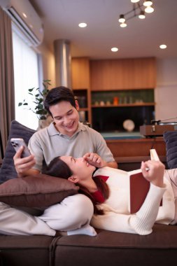 Asyalı bir çiftin evlerinde rahat rahat oturduğu bir anı yakalıyorum. Adam telefonuna bakarken kadın kitap okuyor. Aralarında çok güzel bir bağ var..