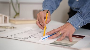 Yaşlı mimarın elleri cetvel ve kalem kullanarak bir plan çiziyor. Mimari plan, tasarım ve mühendislik detaylarına odaklan. Bina planı yapan bir profesyonel. İnşaat için çok önemli. Tasarımcı elleri var..