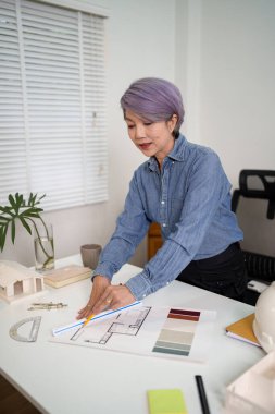 Asyalı Kadın Mimar Çizim Projesi. Profesyonel iç mimar bir ev planı yeniliyor. En iyi Asyalı kadın mimarlar için tasarımımızı gözden geçirin. Çizim planı, hayalinizdeki ev için ilham alın..