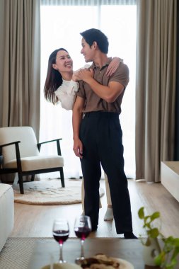 Yetişkin bir Asyalı çift evlerinde sevgi dolu bir anı paylaşıyor. Asyalı kadın, Asyalı erkeği tatlı bir aşk sahnesinin ardından kucaklar ve şarap kadehleriyle modern bir yaşam sürer..