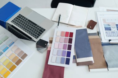 Renk paletleri kumaş örneklerini gösteren yaratıcı çalışma alanı dizüstü bilgisayar ve mimari planlar iç tasarım projesi ilhamı ve profesyonel danışma için idealdir