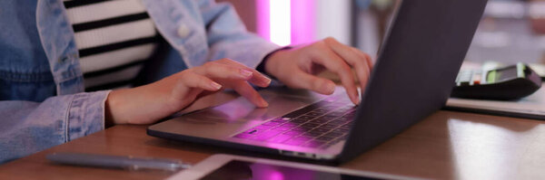 Adult hands engage modern laptop at dynamic shared workspace. Freelancers or nomads achieve productivity with digital tools.