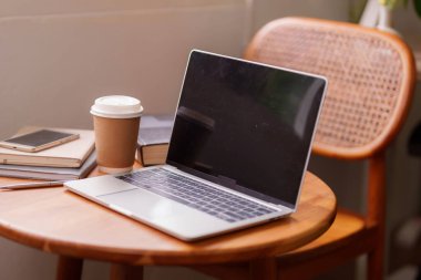 Bilgisayarlı kahve fincanı akıllı telefonu ve kitapları olan modern ofis masası odaklanmış çalışma için mükemmel bir üretken çalışma alanı oluşturuyor.