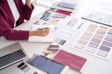 Asyalı yetişkin kadın, yeni ev iç mimarisi yaratıcı planlama süreci için çeşitli malzeme renk örnekleri seçerek konut alanı tasarlıyor