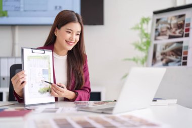 Yetişkin Asyalı kadın mimar, yeni ev geliştirme çözümleri çağdaş ofis sergileyen emlak tasarım istemcisini tartışıyor