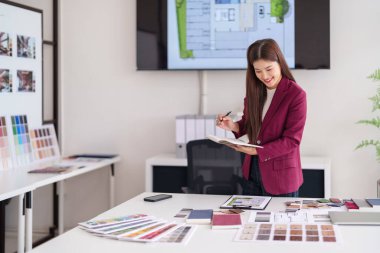 Profesyonel Asyalı mimar konut iç mekanları tasarlıyor. Mimari planları gözden geçirir, materyalleri seçer ve müşteri danışmanlığı sağlar..