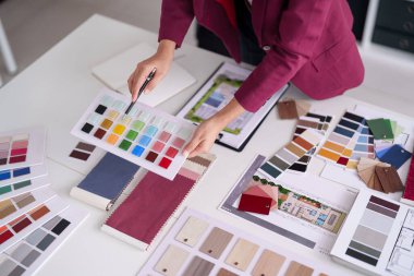 Yetişkin profesyonel el canlı renkte fayanslar seçer. Kumaş örnekleri. Ahşap, modern ev dekorasyonu için geniş bir paletten tamamlanır.