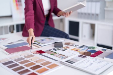 Yetişkin eli modern ofis ortamında mimari tasarım projesi için çeşitli renk kumaş örnekleri ve malzeme örnekleri seçer
