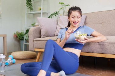 Genç Asyalı kadın besleyici yemek yedikten sonra dinleniyor. Dengeli yaşam tarzı refahı için sağlıklı yiyeceklerin tadını çıkarıyorum..