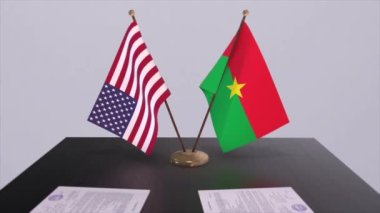 Burkina Faso ve ABD müzakere masasında, diplomatik bir anlaşma. İş ve politika animasyonu. Ulusal bayraklar, diplomasi anlaşması. Kağıt belgeler masanın üstünde. Uluslararası anlaşma