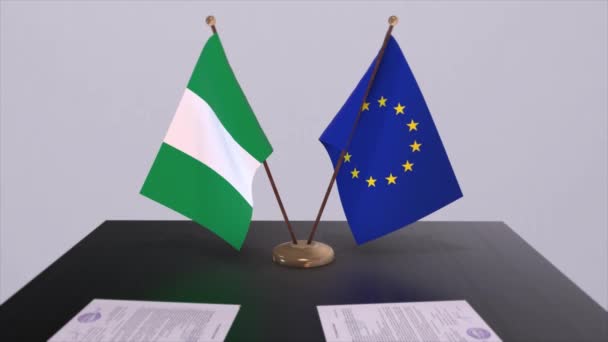 テーブルの上にナイジェリアとEuの旗 国との政治取引またはビジネス契約3Dアニメーション — ストック動画