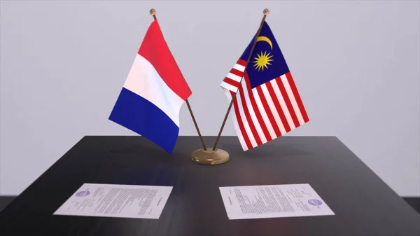 Malaysia and France national flags on table in diplomatic conference room. Politics deal agreement 3D illustration.