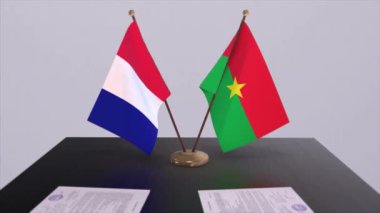 Burkina Faso ve Fransa bayrakları diplomatik konferans odasında masanın üstünde. Siyaset anlaşması