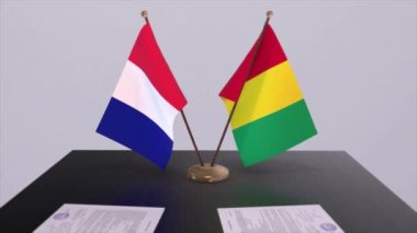 Gine ve Fransa ulusal bayrakları diplomatik konferans odasında masanın üzerinde. Siyaset anlaşması