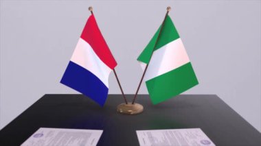 Nijerya ve Fransa ulusal bayrakları diplomatik konferans odasında masanın üzerinde. Siyaset anlaşması