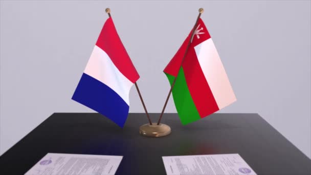 外交会議室のテーブルの上にオマーンとフランスの国旗 政治取引協定 — ストック動画