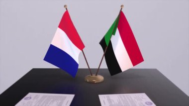 Sudan ve Fransa ulusal bayrakları diplomatik konferans odasında masanın üstünde. Siyaset anlaşması