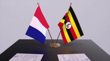 Uganda ve Fransa ulusal bayrakları diplomatik konferans odasında masanın üzerinde. Siyaset anlaşması