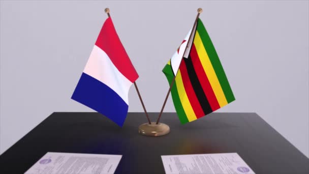 ジンバブエとフランスは外交会議室のテーブルの上に国旗を掲揚している 政治取引協定 — ストック動画