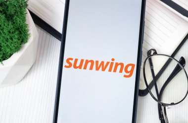 New York, USA - 30 June 2024: sunwing Logo on Phone Screen, Company Icon. clipart