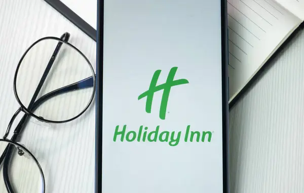 stock image New York, USA - 21 June 2024: Holiday Inn Logo on Phone Screen, Company Icon.