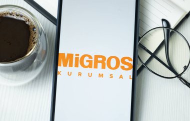 New York, ABD - 21 Haziran 2024: Migros Ticaret Logosu Telefon Ekranı, Şirket Simgesi.