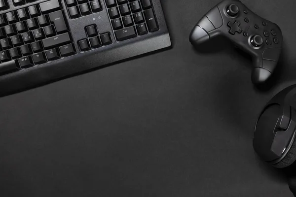 就在游戏台的正上方 游戏控制器用键盘 鼠标放在黑色桌子上 当代简约游戏桌面概念 — 图库照片