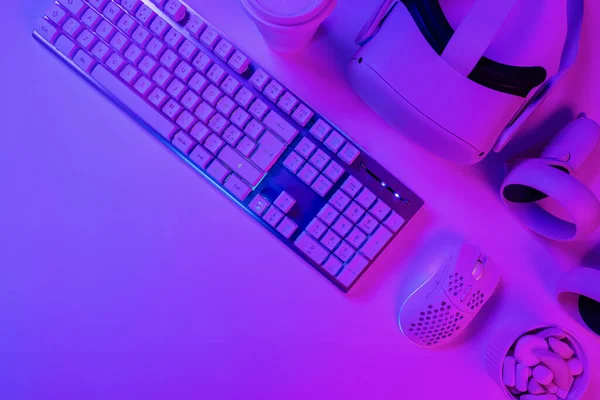 鼠标和游戏配件放在蓝色桌子上的键盘的正上方 — 图库照片