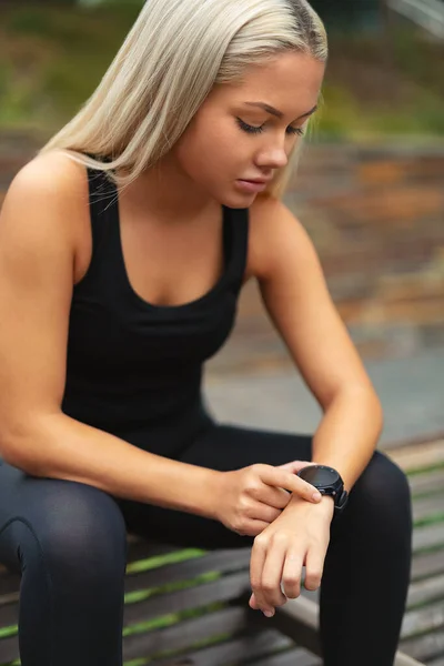 Junge Frau Ruht Sich Nach Training Und Zeitkontrolle Auf Smartwatch — Stockfoto