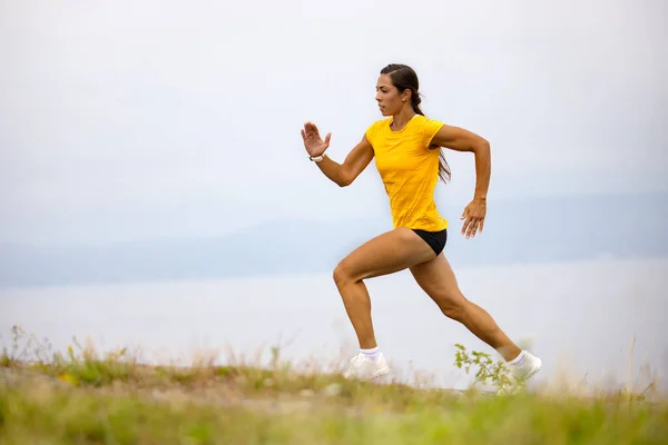 决心坚定的女运动员在室外耐力训练中在山上跑步 — 图库照片