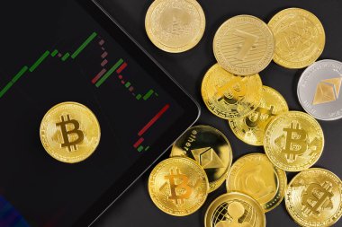 Bitcoin 'in dijital tablet üzerindeki genel görünümü ve çeşitli kripto paraların grafiği