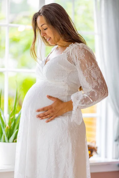 Schöne Lächelnde Schwangere Die Den Fenstern Steht Und Ihren Bauch — Stockfoto