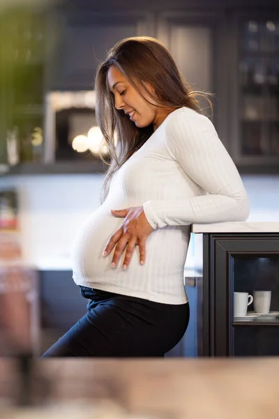 Lächelnde Mutter Berührt Schwangerschaftsbauch Sanft Lässiger Kleidung Glücklich Und Erwartungsvoll — Stockfoto