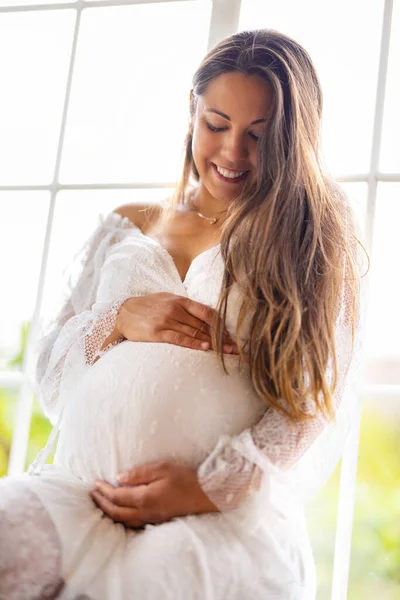 Schöne Lächelnde Schwangere Die Weißem Kleid Fensterrahmen Sitzt Und Ihren — Stockfoto