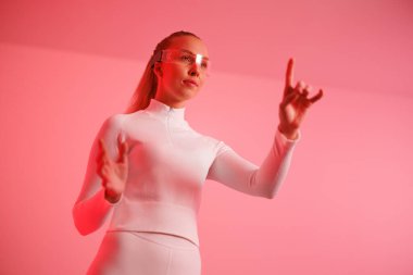 Akıllı gözlük takan ve kırmızı arka planda hareket eden kendinden emin genç bir kadın.