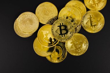 Bitcoin madeni parasının siyah arkaplan üzerindeki çeşitli altın kripto para birimlerinin genel görünümü