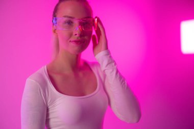 Müziğin ritminde kaybolmuş modern bir birey, kulaklıkları parlak pembe bir ışıkta, ticari ve yaratıcı kullanım için serin ve modaya uygun titreşimler yayıyor..